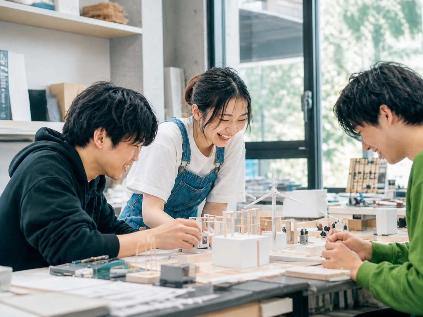 建築模型を囲んで制作する架空の学生たち